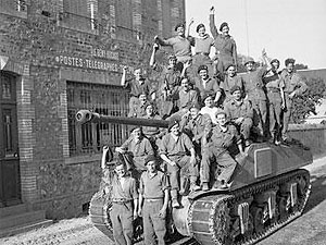 1er août 1944 – Sur un Sherman Firefly, des soldats britanniques fêtent la capture du Bény-Bocage. © IWM B8343